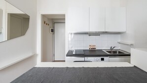 Una cocina moderna con gabinetes blancos, un lavaplatos de acero inoxidable y un lavavajillas.