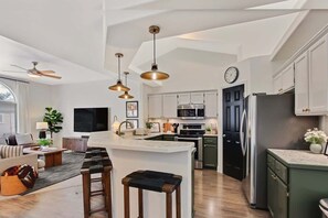 A modern kitchen with a central island, pendant lighting, and a large window. - Stylish 3BR/2BA Home near Park (Boise)