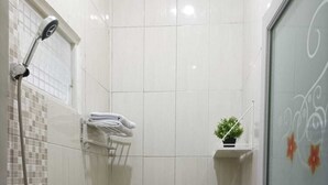 Un baño pequeño y limpio con inodoro, lavamanos y ducha.