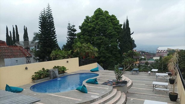 Una piscina en la azotea con cascada, rodeada de escalones y zonas de estar.