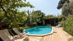 A wooden deck with a swimming pool, surrounded by lush greenery and trees. - 3 bedroom gorgeous home in Orbicciano (Orbicciano)