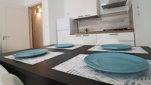 Una cocina moderna con armarios blancos, extractor de acero inoxidable y encimera de madera.