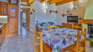A cozy room with wooden furniture, a bed with a floral bedspread, a television, and a fireplace. - Apartment La Gran Becca - ID 3946 (Antey-Saint-Andre)