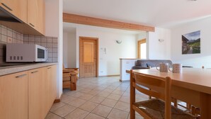 Une cuisine moderne dotée de meubles en bois, d’un four à micro-ondes et d’un coin repas avec une table et des chaises.