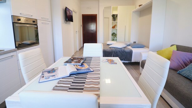 A modern, compact living space with a kitchenette, a dining area, and a bedroom. - Holiday House 'casa Vacanze Alba A Otranto' With Balcony and air Conditioning (Otranto)