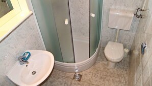 Kylpyhuone, jossa on suihkukaappi, pesuallas ja wc.