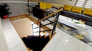 Una sala de estar moderna con una escalera, un sofá y una mesa de centro.