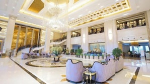 A spacious lobby with a grand chandelier, a central fountain, and a staircase leading to upper levels. - Jasmine International Hotel (Renshou)