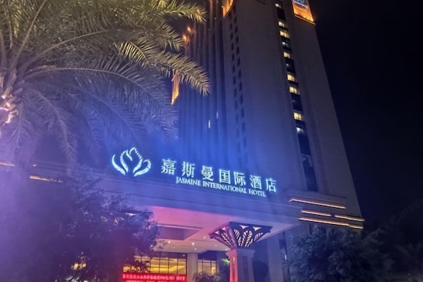 The exterior of Jasmine International Hotel with illuminated signage and a modern architectural design. - Jasmine International Hotel (Renshou)