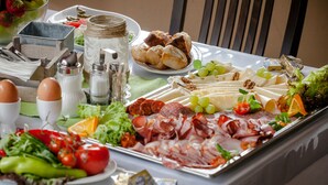Una mesa con una variedad de alimentos, incluyendo carnes, quesos y verduras.