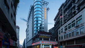 A modern hotel with a curved facade, multiple floors, and a prominent sign with Chinese characters. - Vienna Hotel (Jishou Railway Station) (Jishou)