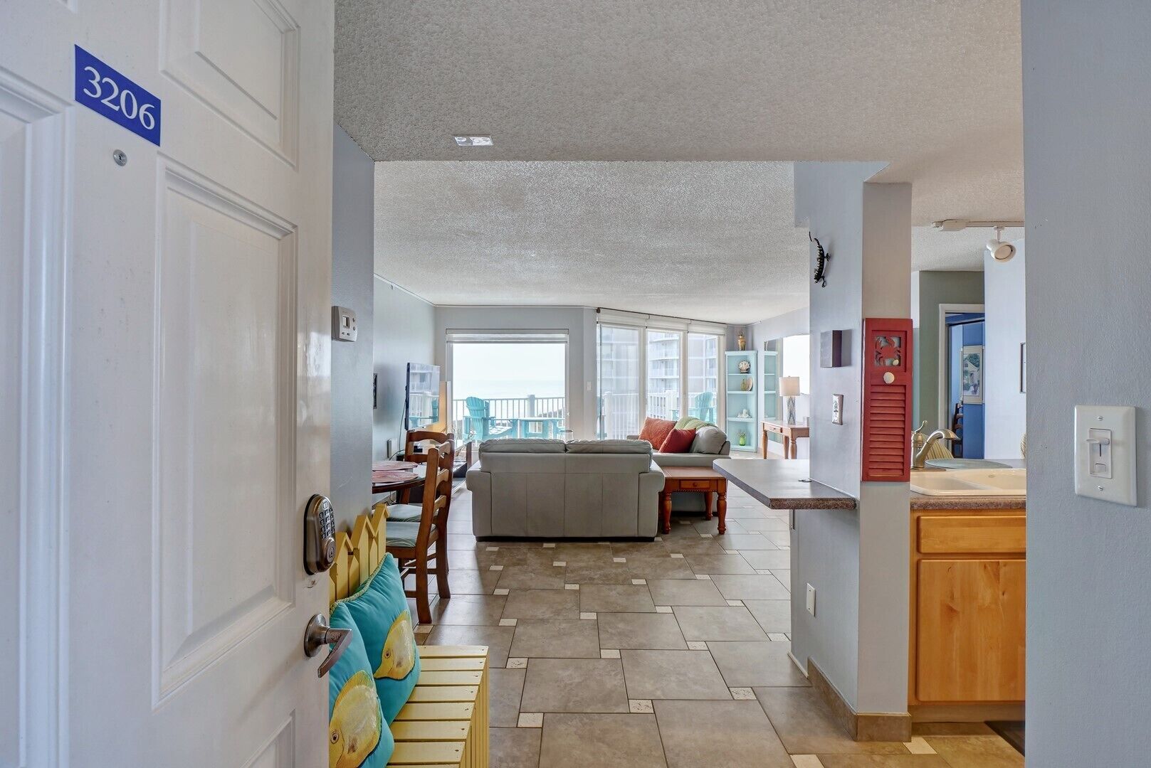 A spacious living area with a dining table, sofa, and a view to the outside.