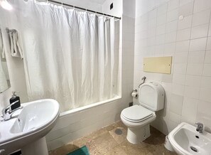 Ein Badezimmer mit Badewanne, Toilette, Waschbecken und Bidet.