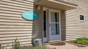 En byggnad med en skylt som visar texten ”Living Well 410” och en dörr med ett fönster.