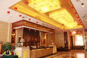A hotel lobby with a reception desk, a large chandelier, and red lanterns. - Xingtian Hotel (Yueyang)