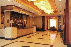 A hotel lobby with a reception desk, a large chandelier, and a clean, polished floor. - Xingtian Hotel (Yueyang)