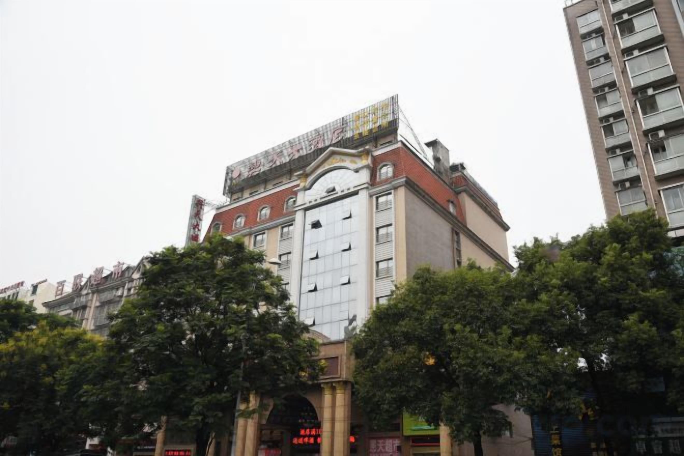 A multi-story building with a prominent entrance, large windows, and a flat roof.