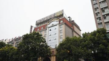 Um edifício de vários andares com entrada imponente, grandes janelas e telhado plano.