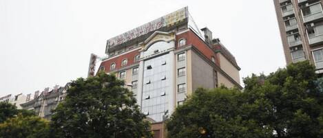 A multi-story building with a prominent entrance, large windows, and a flat roof.