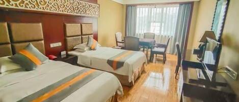 A hotel room with two beds, a desk, a chair, a television, and a window with curtains.