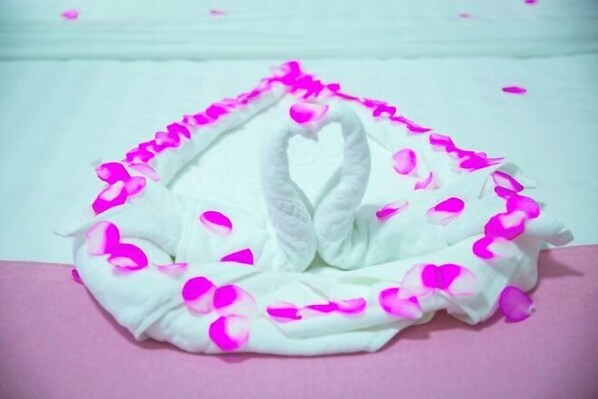 A white swan-shaped decoration with pink petals. - Xingtian Hotel (Yueyang)