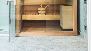 A sauna with a wooden interior, a bench, and a small wooden cabinet. - Villa The Grapes and the Stars in Orvieto (Porano)