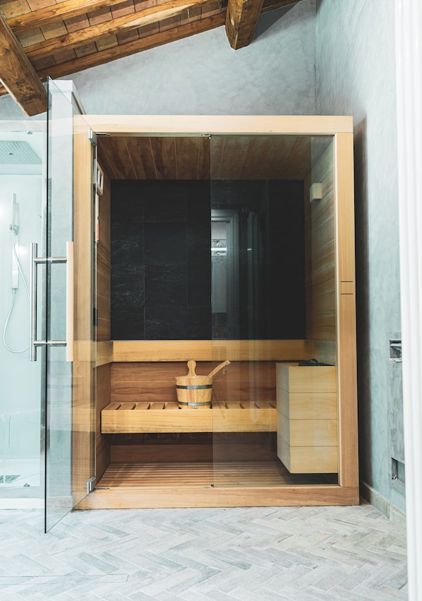 Una sauna con interior de madera, un banco y un pequeño armario de madera.