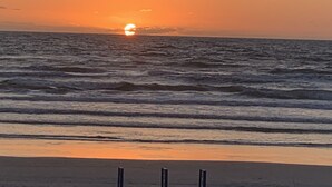 Una playa con olas y un atardecer.