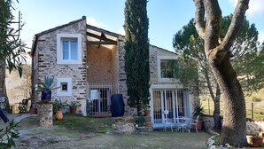 Un bâtiment en pierre doté d’un balcon et d’un espace extérieur aménagé pour s’asseoir.