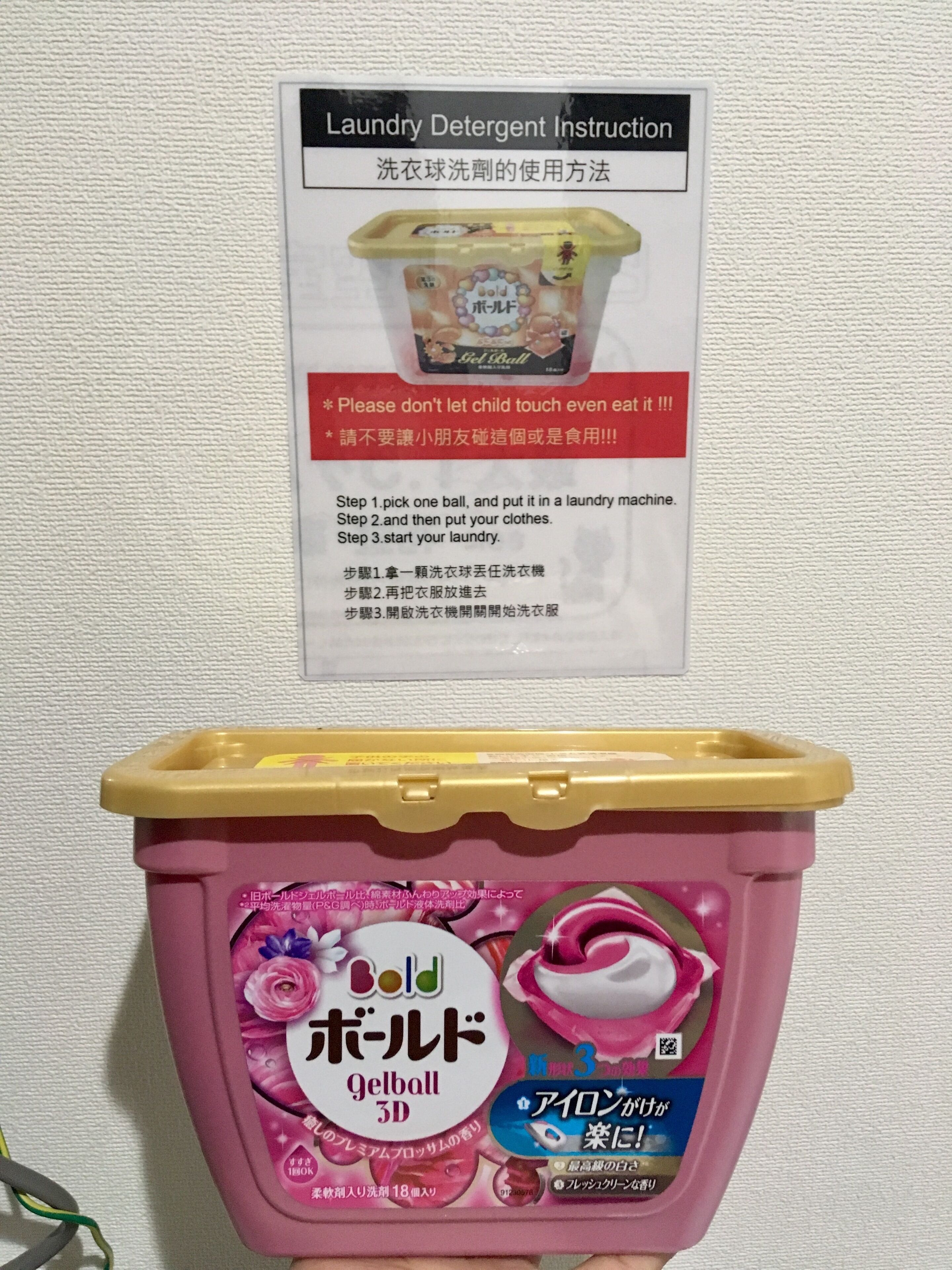 A container of laundry detergent instructions and a pink container of Bold Gelball 3D.