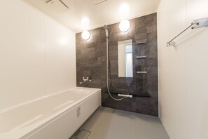 Departamento Deluxe | Baño | Tina con regadera, secadora de cabello, pantuflas, bidet 