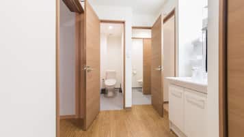 Deluxe appartement | Badkamer | Een bad/douchecombinatie, een haardroger, pantoffels, een bidet