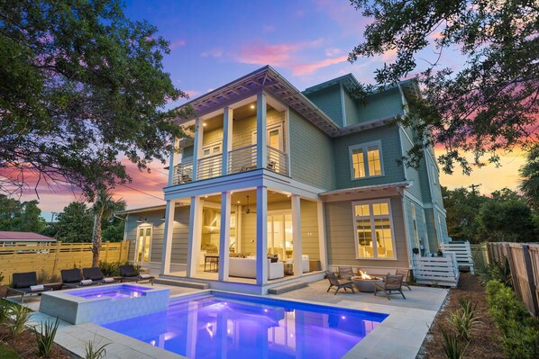 A two-story house with a covered patio, a swimming pool, and a deck.