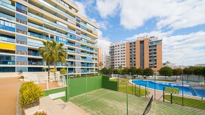 A multi-story hotel with balconies, a swimming pool, and a tennis court. - Apartment 'Beach and Green' with Sea View, Wi-Fi and Air Conditioning (Alicante)
