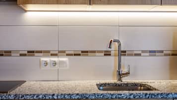 Een koelkast, een oven, een kookplaat, een vaatwasser