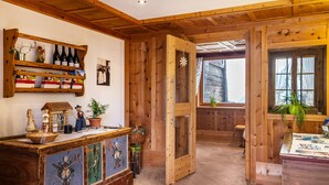 Een houten interieur met een houten deur, een plank met wijnflessen en een rustieke inrichting.