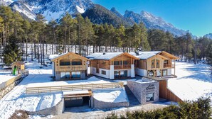 Un bâtiment de style chalet, avec des fondations en pierre, un revêtement extérieur en bois et de grandes fenêtres.
