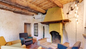 A rustic interior with a fireplace, wooden beams, and modern seating. - Workation Castle: Casa Tremezzo (Carlazzo)