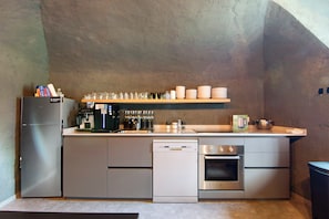 A compact kitchen with a refrigerator, dishwasher, oven, and a coffee station. - Workation Castle: Casa Tremezzo (Carlazzo)
