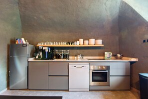 A compact kitchen with a refrigerator, dishwasher, oven, and a coffee station. - Workation Castle: Casa Galbiga & Casa Tremezzo (Carlazzo)