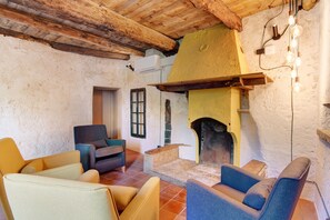 A rustic interior with a fireplace, wooden beams, and modern seating. - Workation Castle: Casa Galbiga & Casa Tremezzo (Carlazzo)