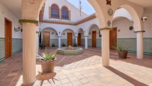 A courtyard with arches, columns, and potted plants. - Holiday Home 'Cabrera' with Sea View, Private Pool and Wi-Fi (Puntalon)