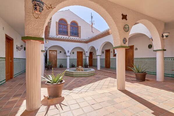A courtyard with arches, columns, and potted plants. - Holiday Home 'Cabrera' with Sea View, Private Pool and Wi-Fi (Puntalon)