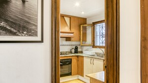 A kitchen with wooden cabinets, a stainless steel sink, and a stove. - Villa 'Olivera' with Private Terrace and Private Garden (L'Escala)