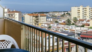 A balcony with a view of a coastal cityscape, including buildings and a marina.