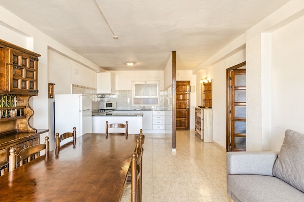 Une cuisine spacieuse avec un coin repas, des meubles en bois et un four encastré.