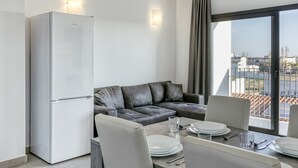 Un salon moderne avec un canapé, une table à manger et un réfrigérateur.