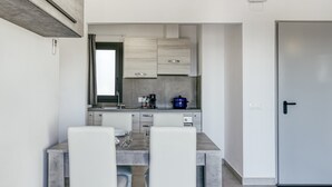 Une cuisine moderne équipée d’une table et de chaises, d’une cuisinière et d’un réfrigérateur.