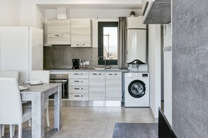 A modern kitchen with a dining area, built-in appliances, and a view through a window.