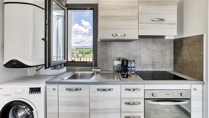 A compact kitchen with a built-in washer, a sink, and a stove.